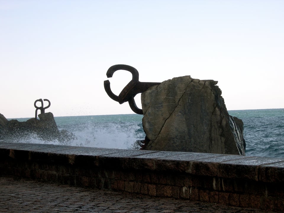The view of two large steel sculptures, weighing 10 tons each, embedded in natural rocks rising from the sea.
