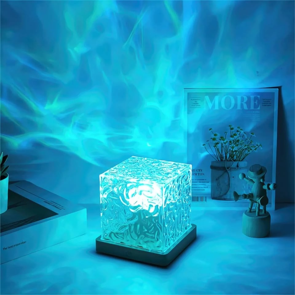 a clear blue plastic cube, glowing blue, casting swirly lights on the walls of a room