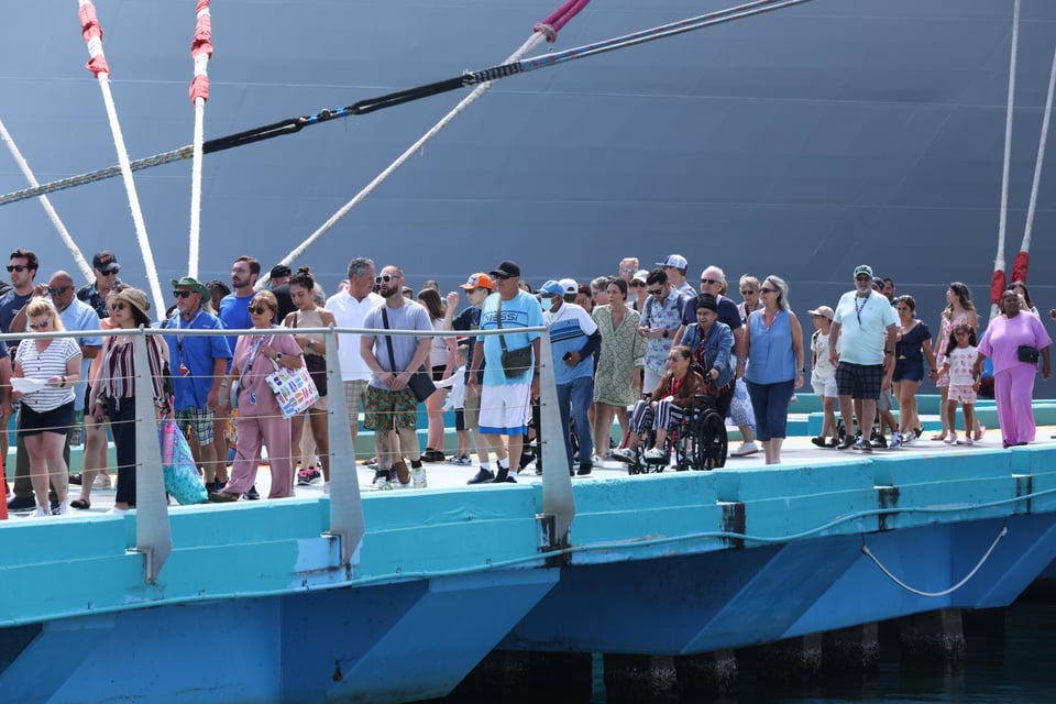 Tourists get off of a cruise ship