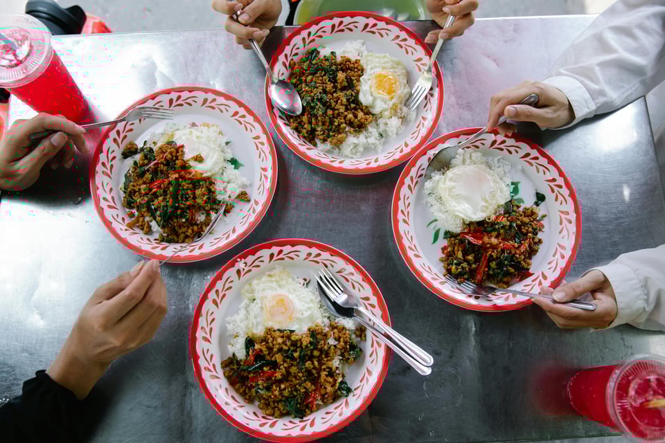 Four red and white bowls of what looks like pork and holy basil, plus fried eggs thrown on top, which is an extremely popular dish.