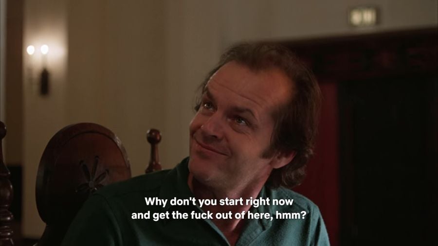 Jack Torrance looking up at his wife with a smug fucking look on his face. The subtitle over the screenshot says “Why don’t you start right now and get the fuck out of here, hmm?”