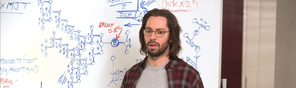 Martin Starr as Gilfoyle in Silicon Valley stands in front of a whiteboard featuring complex charts and equations, all relating to how many men the core cast could efficiently jack off within ten minutes. 