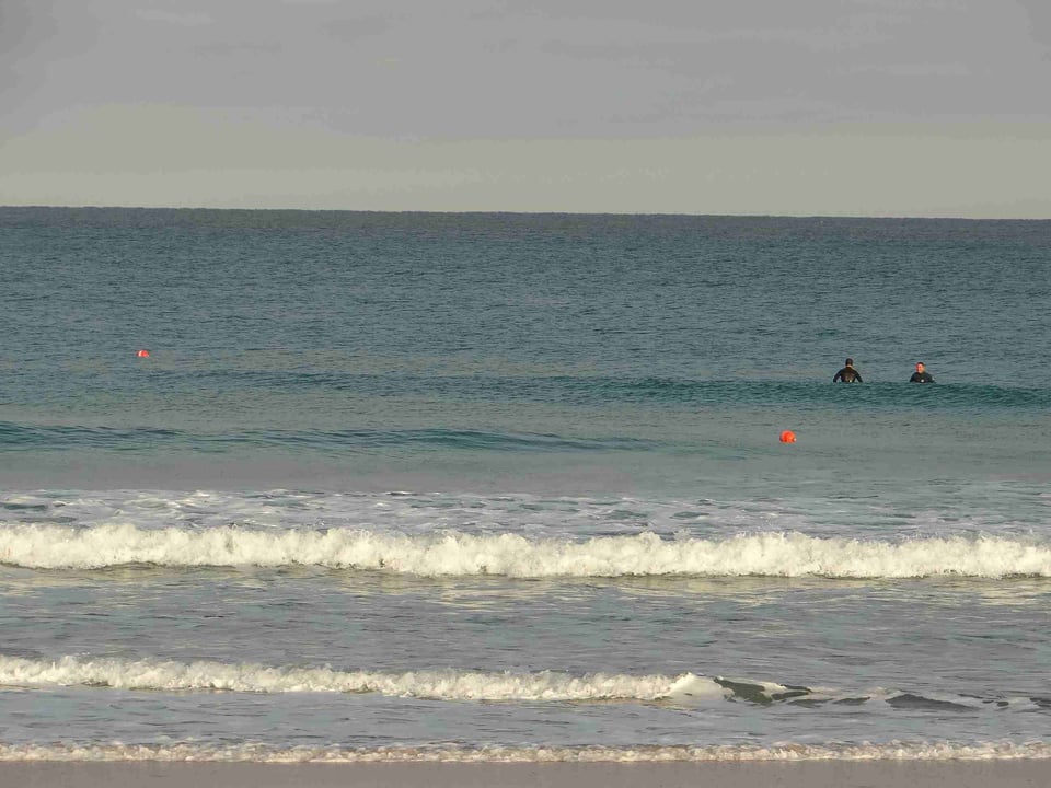 2 surfeurs évoluent à quelques mètres d'un filet fixe posé à marée basse et signalés par deux bouées bien visible. Il sera retiré à la prochaine marée basse, 12 heures plus tard.