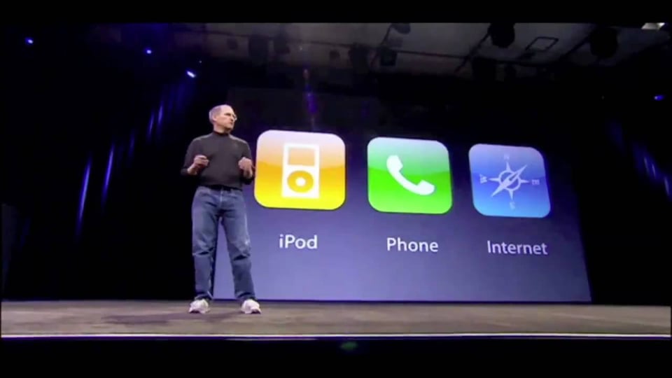 Steve Jobs in dad jeans in front of a screen with losenges representing iPod Phone Internet