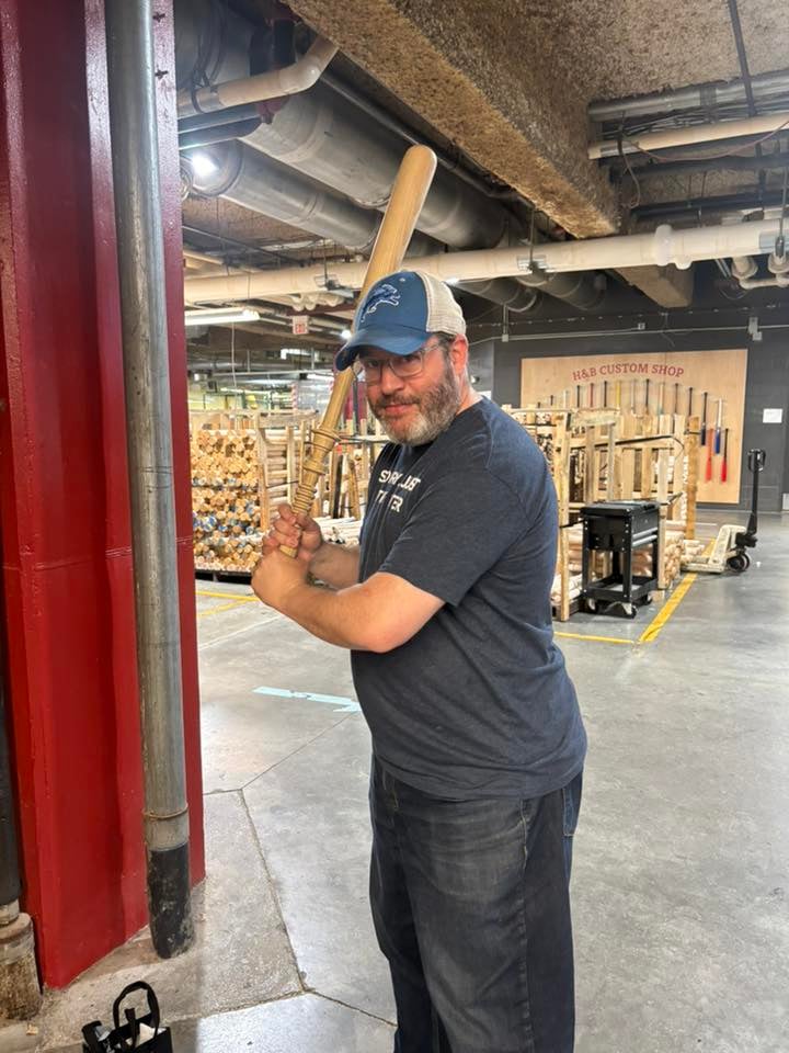 neil holding a baseball bat carved to look like a lightsaber at the lousiville slugger museum in kentucky