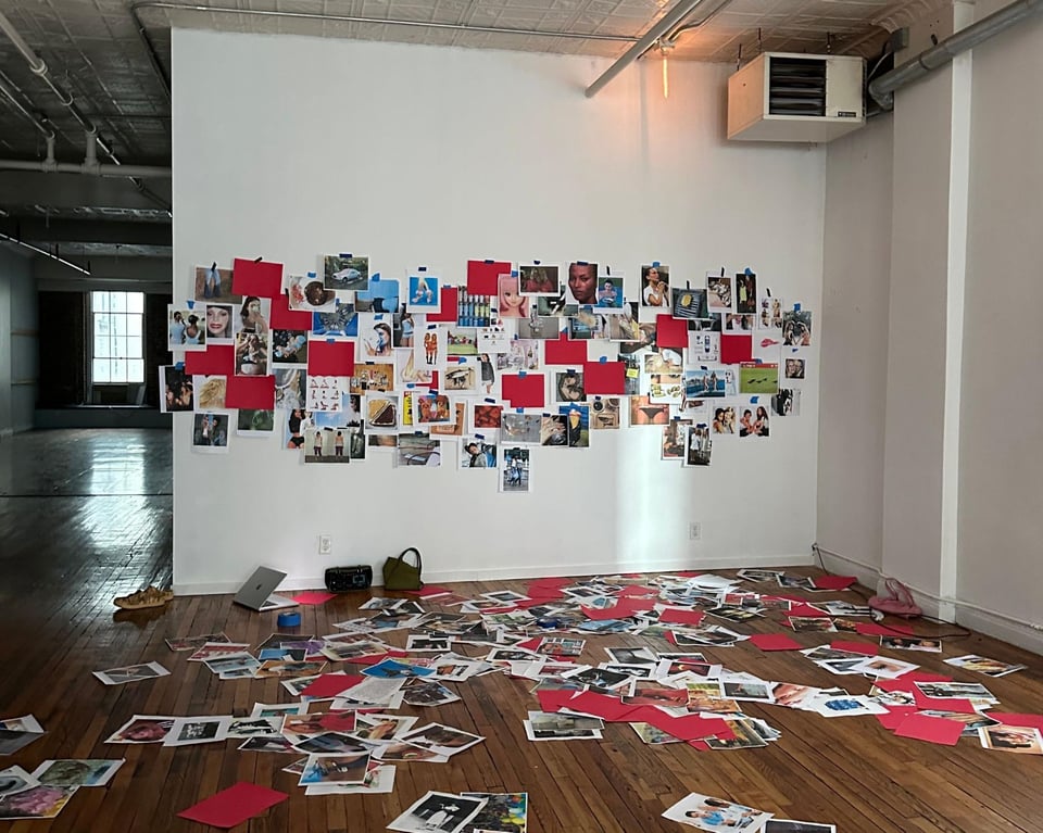 Images printed on computer paper scattered across the floor and pinned to the wall.