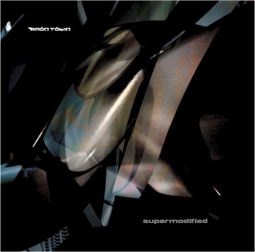 The cover of Amon Tobin’s SUPERMODIFIED album. Hard to describe — a bunch of smooth, abstract shapes in grey blue and grey brown on a black background. It’s probably actually something but I couldn’t tell you what.