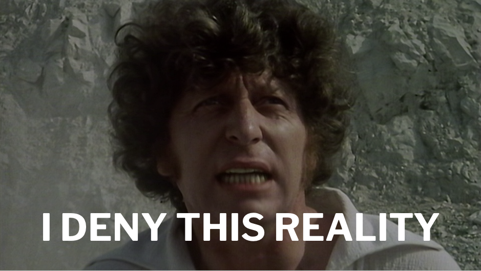 A photo of Tom Baker, a white guy with a curly mop of hair, shouting in a gravel quarry wearing a white poet shirt, from episode three of Doctor Who, "The Deadly Assassin." Tom Baker is shouting, "I DENY THIS REALITY"