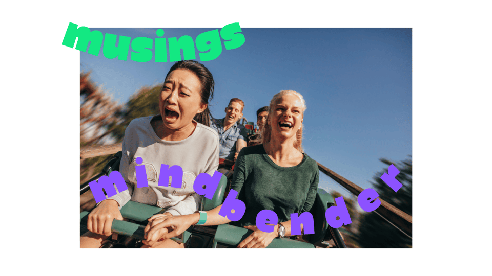 2 young women at the front of a rollercoaster car; the East Asian woman on the left looks about to cry while her blonde friend is all smiles