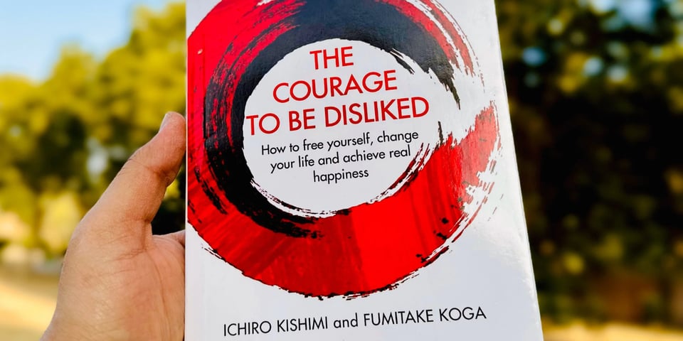 A book cover with big red letters - The Courage to Be Disliked.