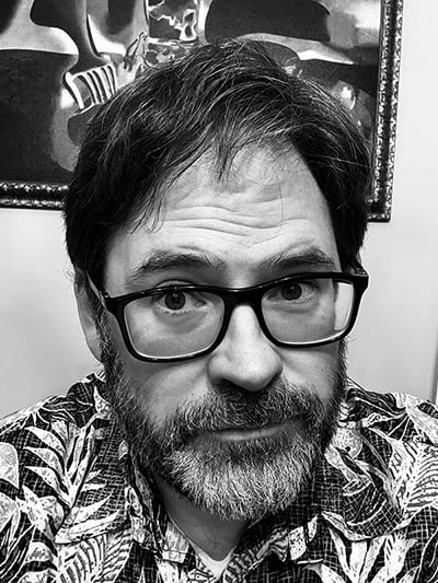 This is a selfie of me, Leighton Connor, in black and white. I am wearing a Hawaiian shirt.