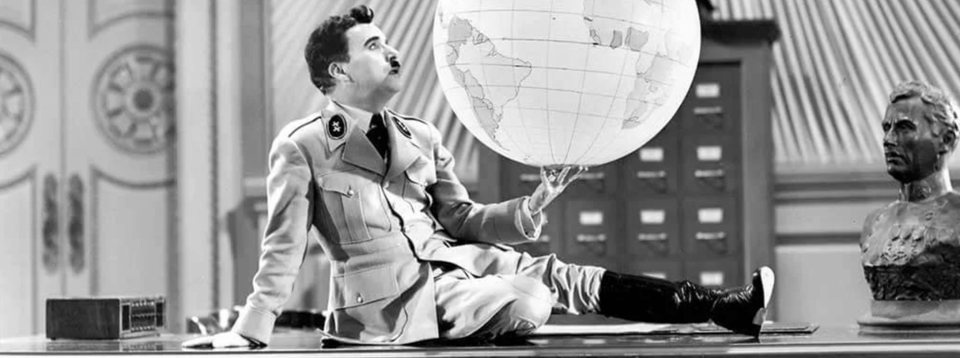 Charlie Chaplin, dressed in a parody of Hitler, gazes lovingly at a globe.