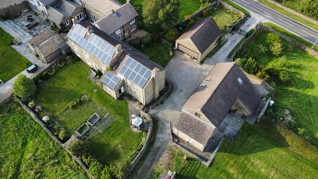 An aerial photograph of Wild & Other, showing solar panels on the roofs of the farm buildings