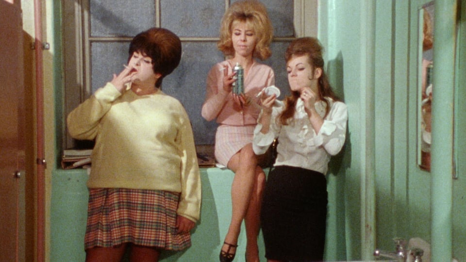 Screencap from Female Trouble. Three high school girls with amazing hair smoking in the bathroom.