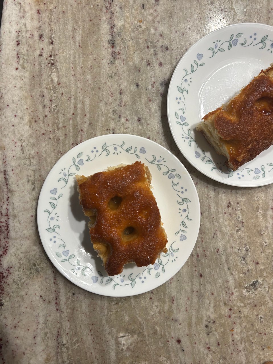 Two slices of brown sugar "focaccia" cake on white plates.