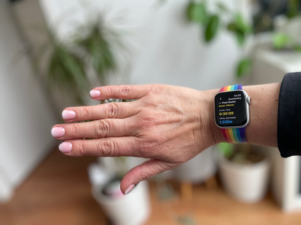 White/pink gradient manicure and my apple watch showing my workout summary for that morning's swim of 35 mins and 1025 meters.