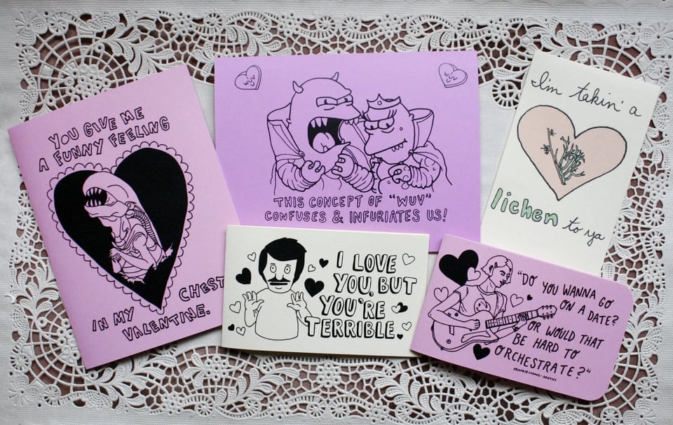 various illustrated valentines displayed on a paper doily.