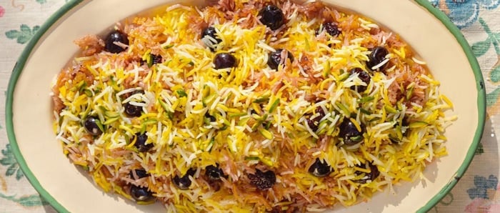 An oval platter with a golden rice pilaf studded with sour cherries and other goodies