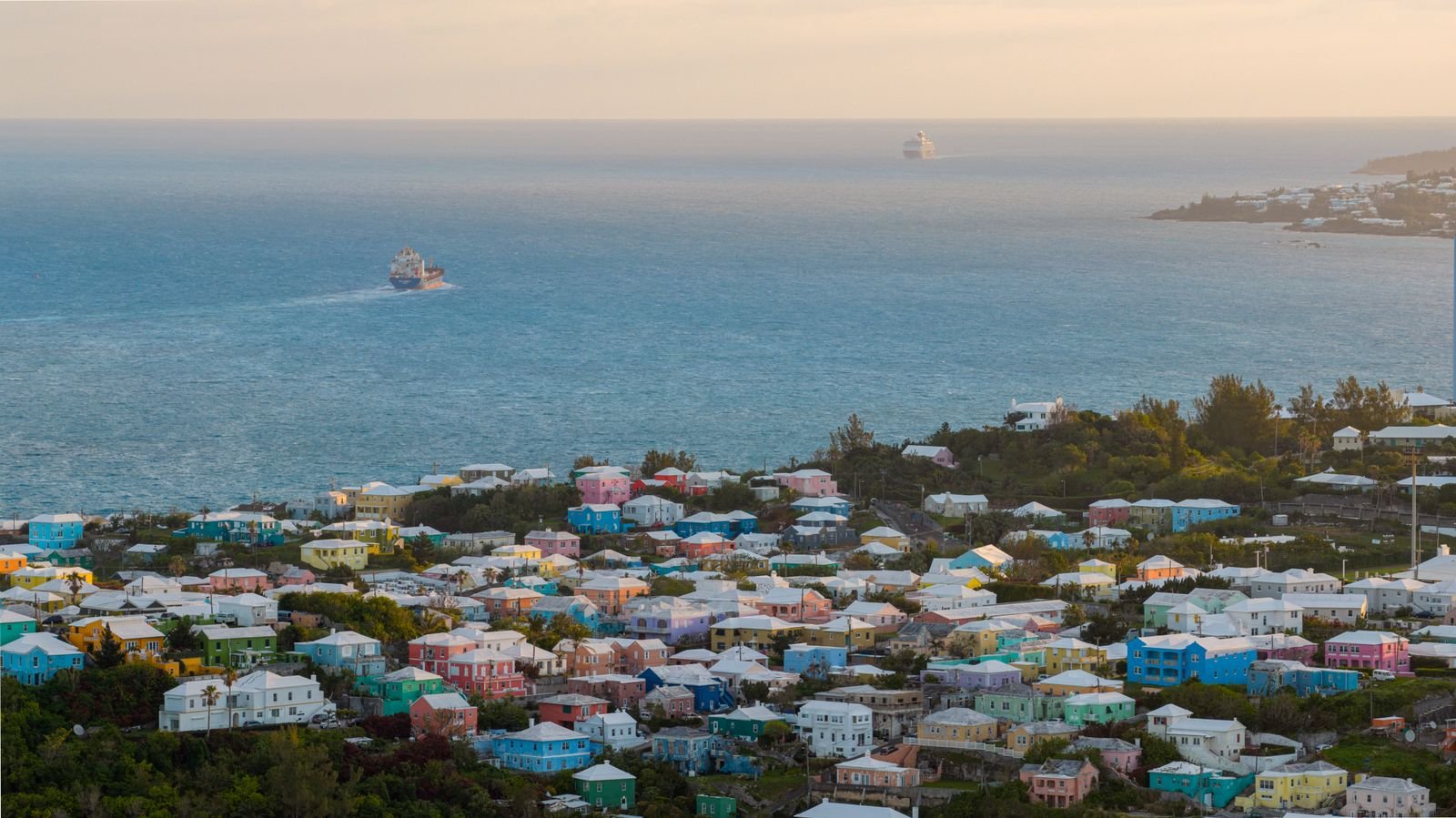 Aerial view of colorful Bermudian houses with white stepped roofs along the Atlantic coast