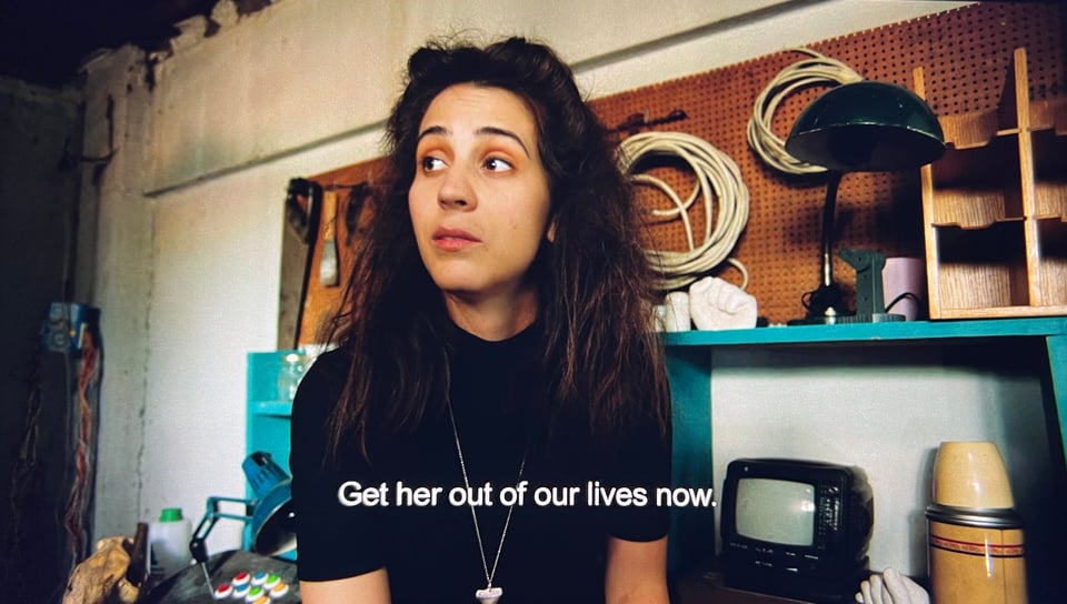 woman with shoulder length dark hair looking skeptical and text that reads get her out of our lives now