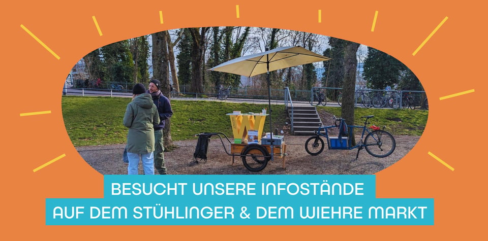 Foto vom Infostand (Fahrradanhänger mit W-Tisch und Schirm) auf dem Stühlinger Markt mit zwei Personen im Gespräch davor. Darunter der Text "Besucht unsere Infostände auf dem Stühlinger & dem Wiehre Markt".