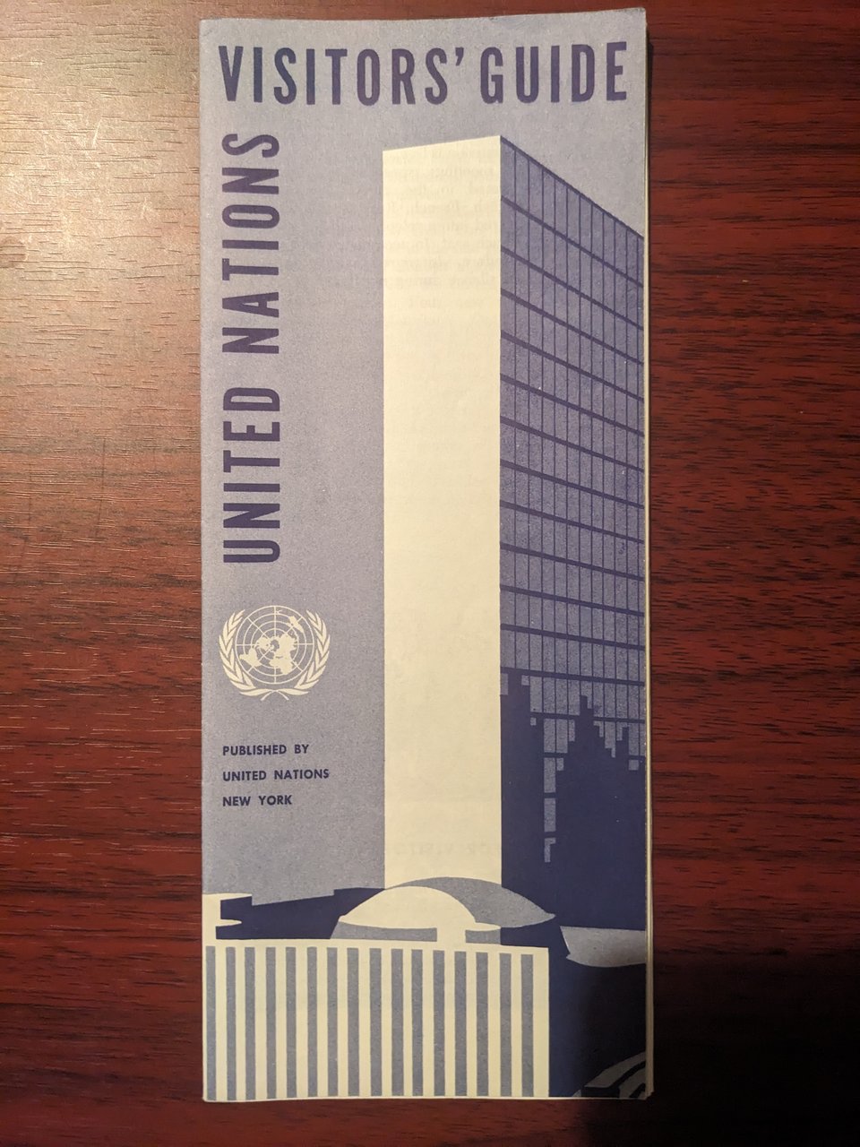 Cover of a United Nations Visitors Guide, with the UN Secretariat Building and General Assembly video building on a light blue background.