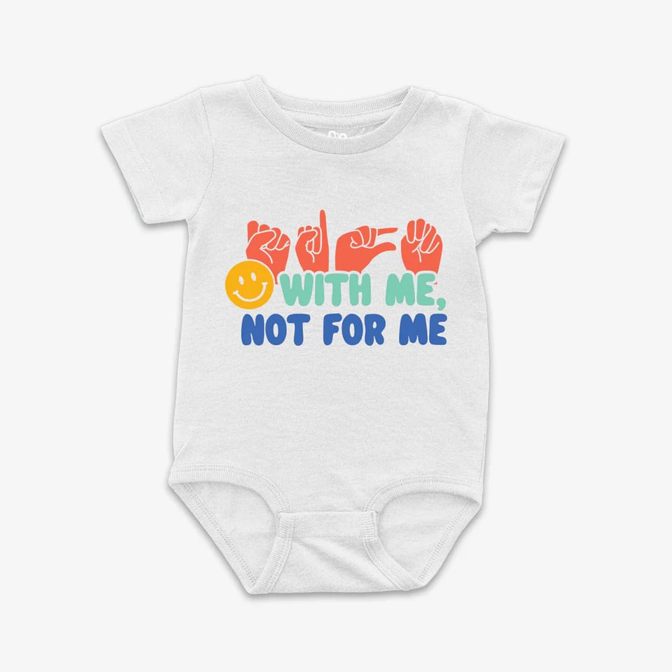Commercial image of a baby onsie on a blank background. The white shirt has the words "Sign with me, not for me" printed on the front, along with a smiley face. The word "sign" is written in ASL fingerspelling, showing hands making the letters S-I-G-N.