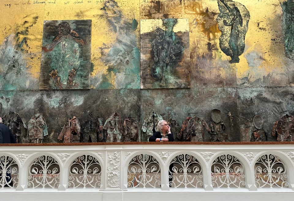 Photo of woman looking at a massive art installation by Anselm Kiefer