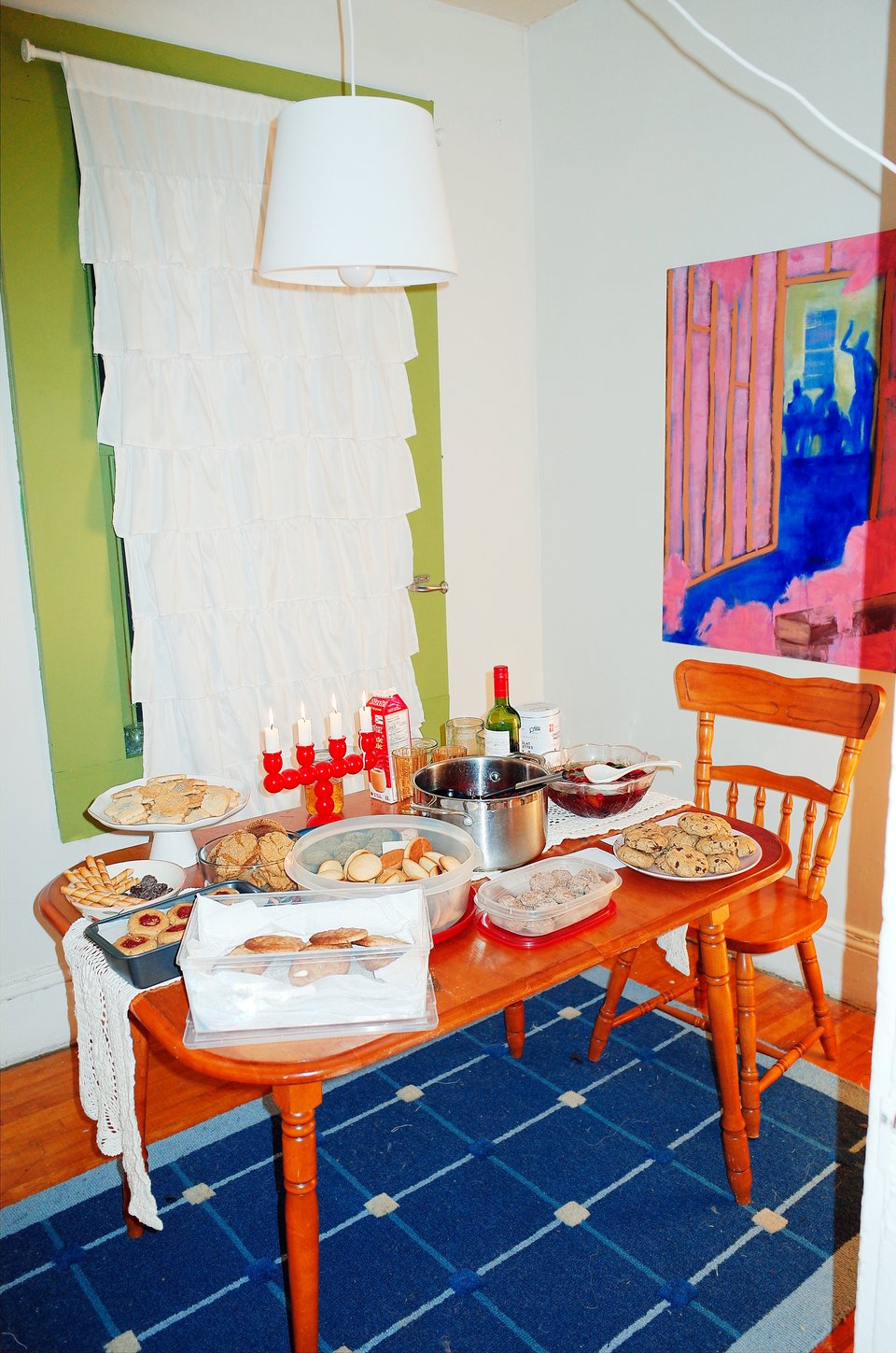 Flash photograph of a table laden with many different kinds of Christmas cookies