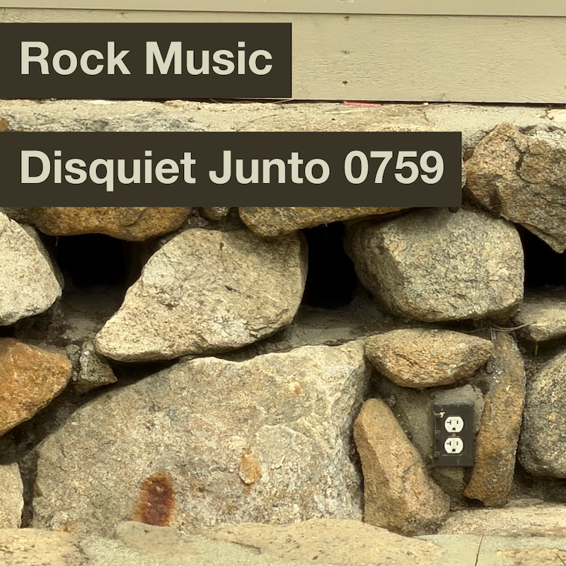 A wall of rocks with an electrical outlet, plus the name and number of the project