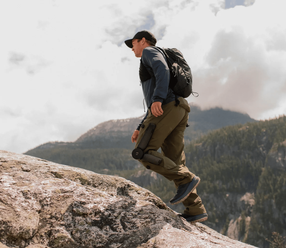 A person wearing a robotic-assisted knee brace in the woods.