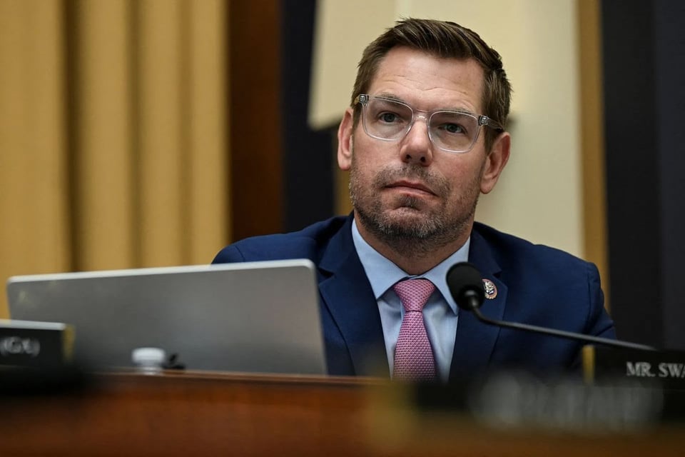 Eric Swalwell sitting in front of a laptop and a microphone.