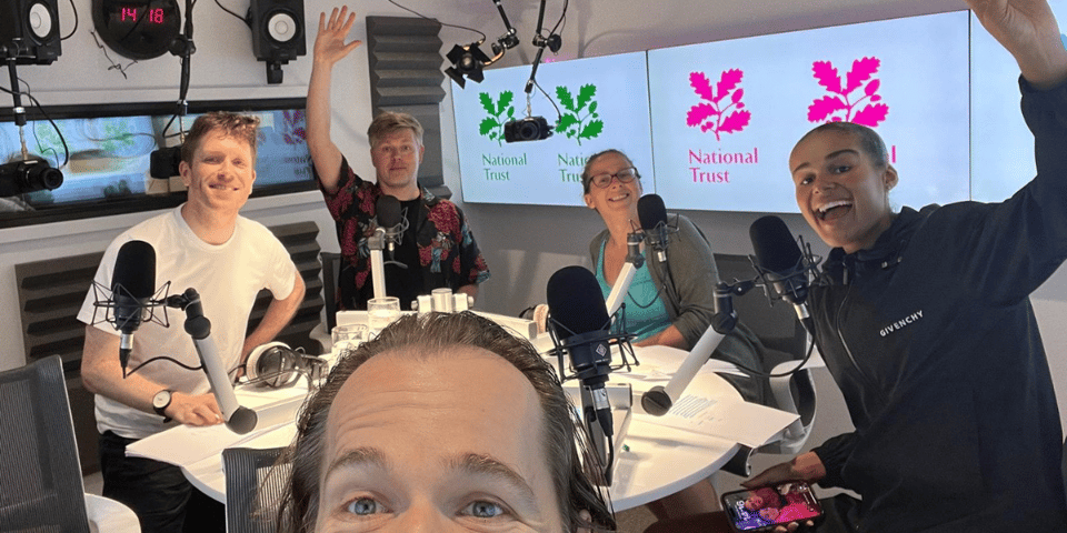 A bunch of smiling improvisers at a podcast studio.