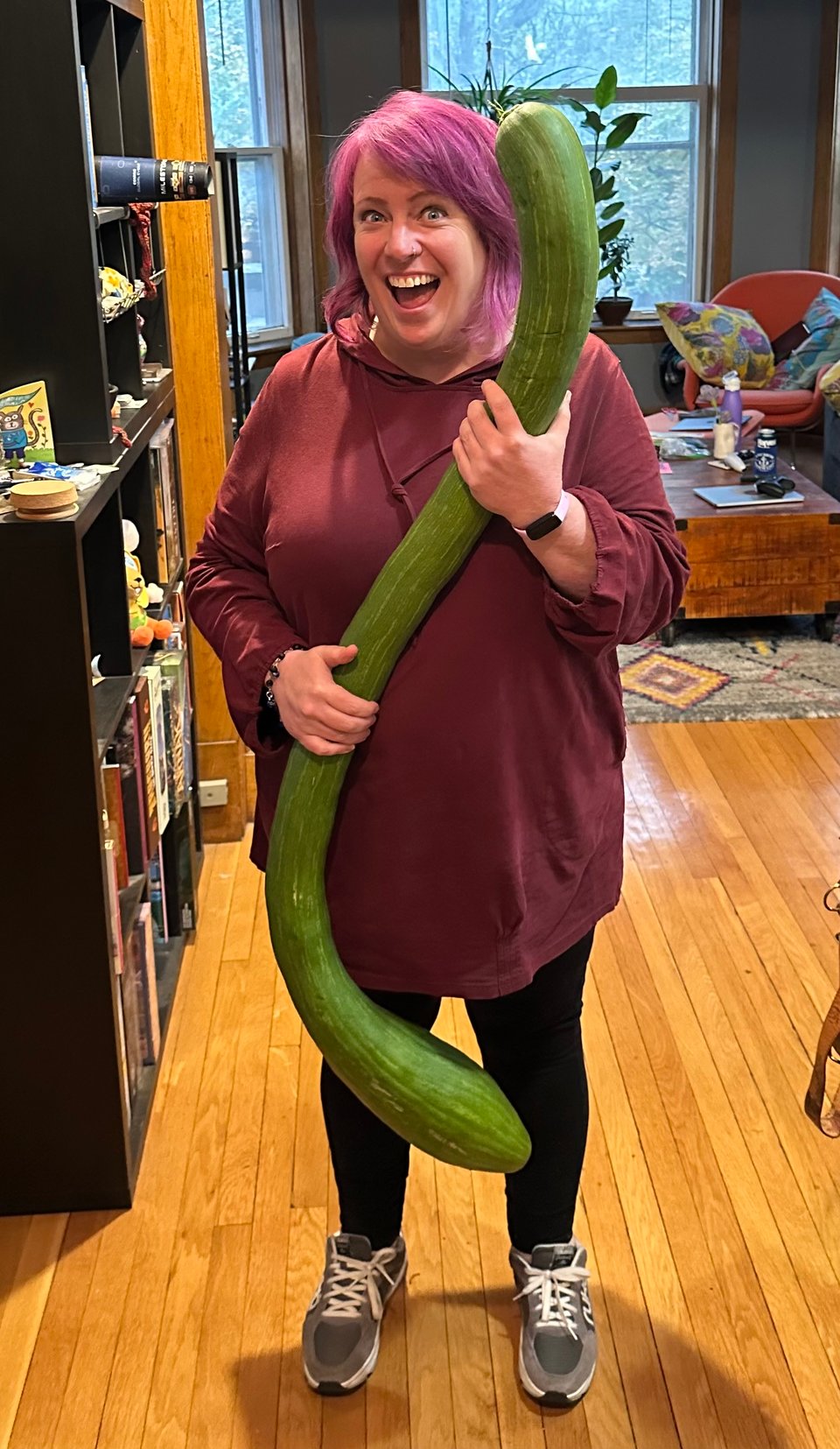 Yours truly, 5 foot 5 inches tall, holding a long squiggly tromboncino squash that's nearly as tall as me. It weighs 13 pounds!