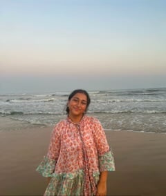 A young woman standing on a beach.