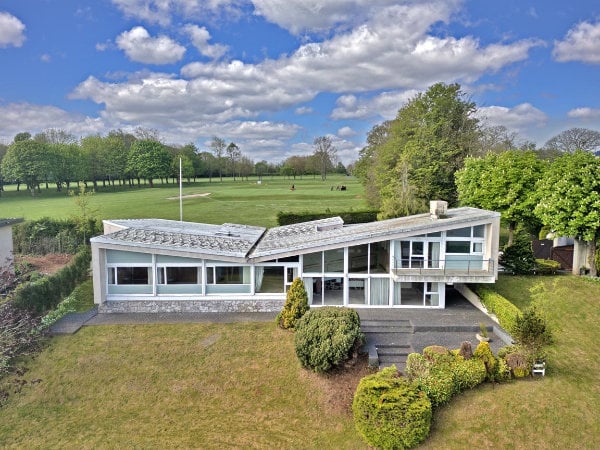 A 1960s house. It's mostly single storey but it has an asymetrical butterfly roof. Where the roof is highest, a second story of house is fitted complete with a balcony.