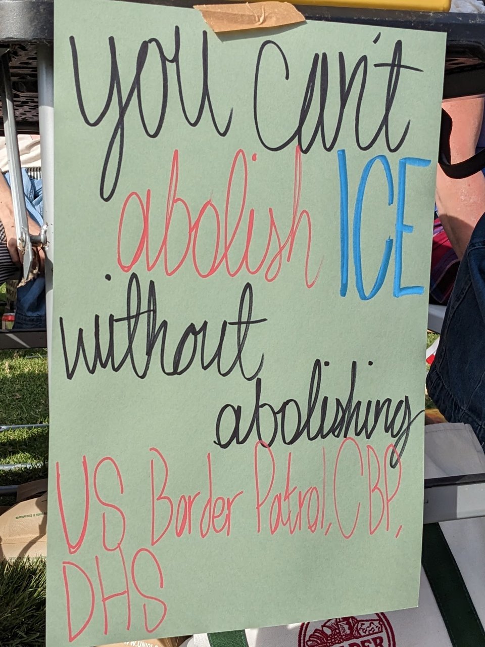 protest sign that reads, "You can't abolish ICE without abolishing US Border Patrol, CBP and DHS."