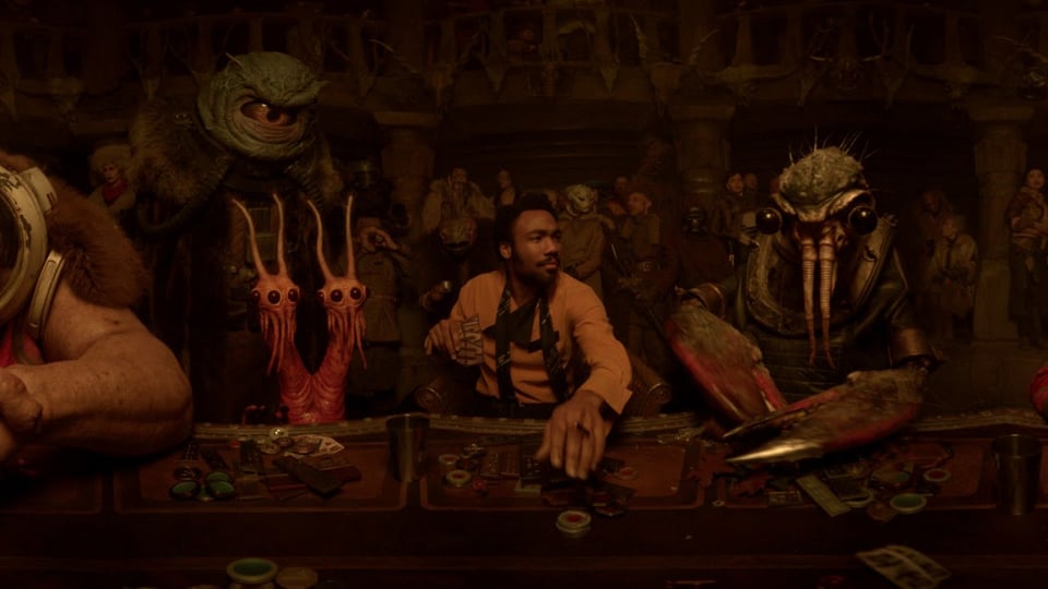 an image of lando calrissian, therm scissorpunch and other characters from the movie solo: a star wars story, sitting at a table and playing cards