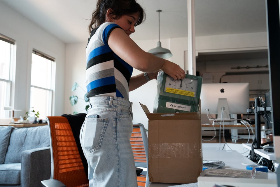 Livvy pulling a time clock out of a box.