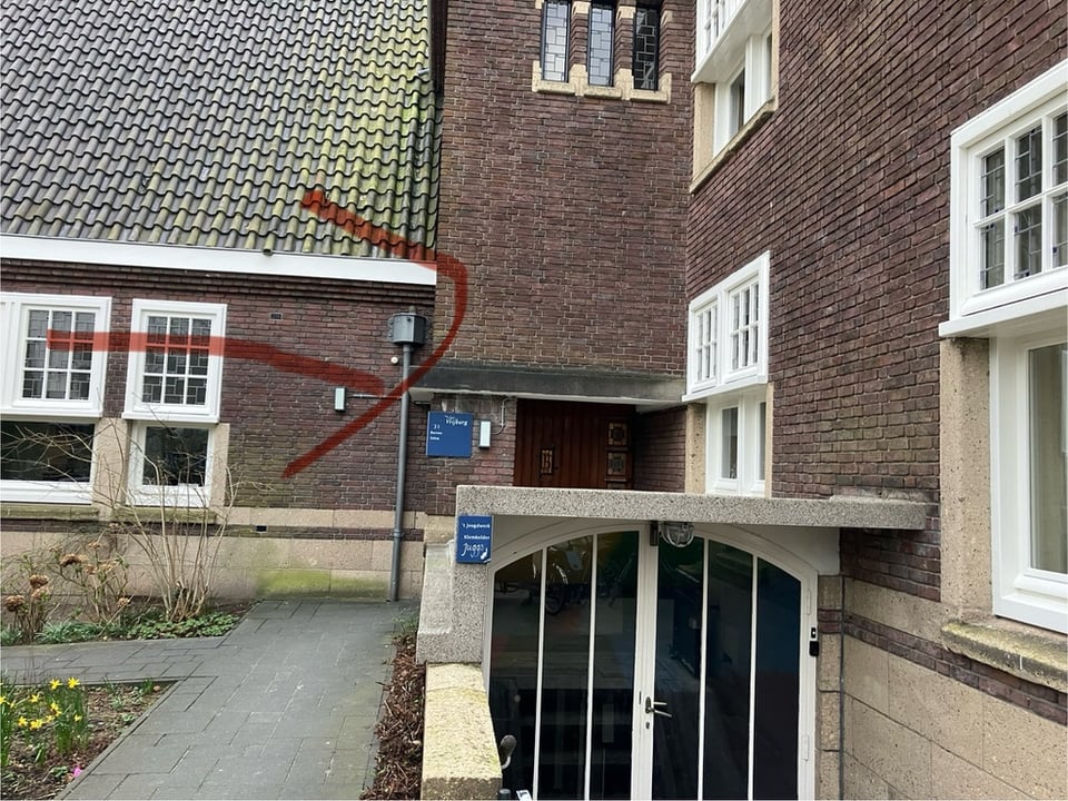 A red arrow indicates a door, the farthest of two from the street. A small blue sign identifies it as house number 31