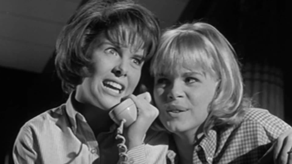 Two horrible teens hold a phone receiver to their ears, mocking the person on the other end, in I Saw What You Did.