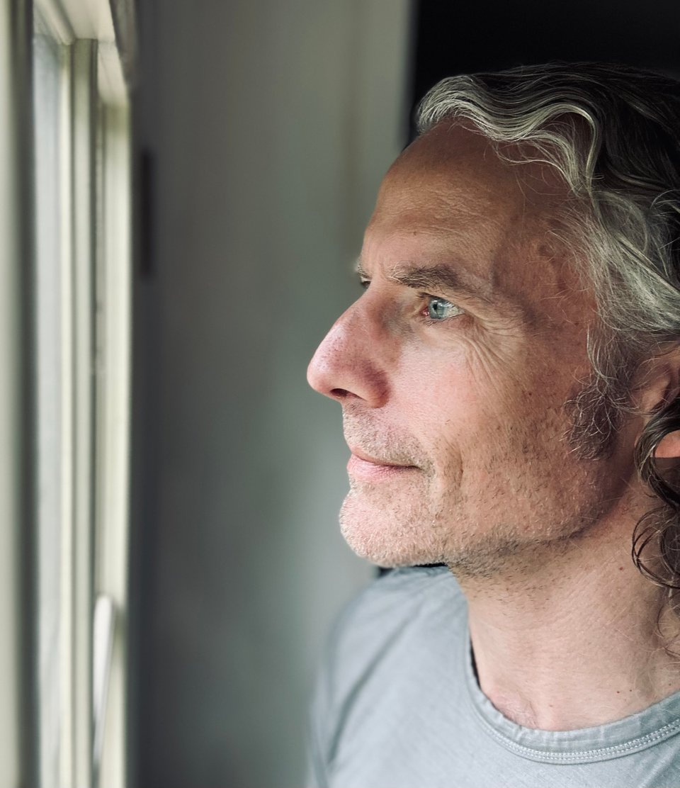 Profile selfie of white man with long graying hair