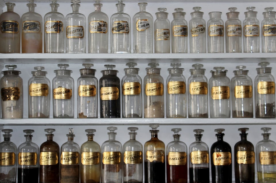 Apothecary jars in a line for healing and potions.