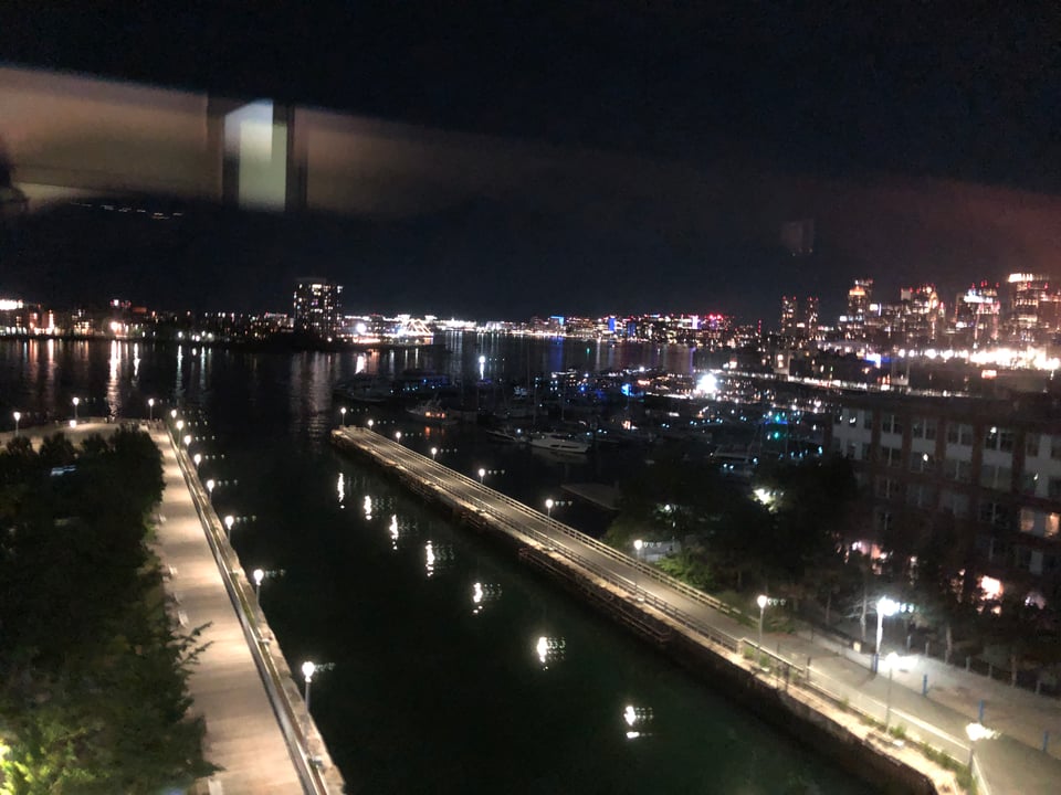Nighttime view out a hospital window of Boston Harbor, East Boston, and downtown