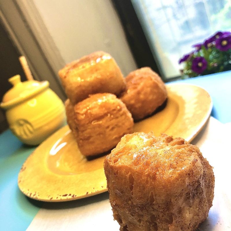 a puffy angel donut pastry in front of four stacked on a plate.