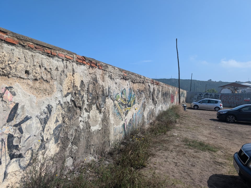 A crumbling old wall covered with fading graffiti