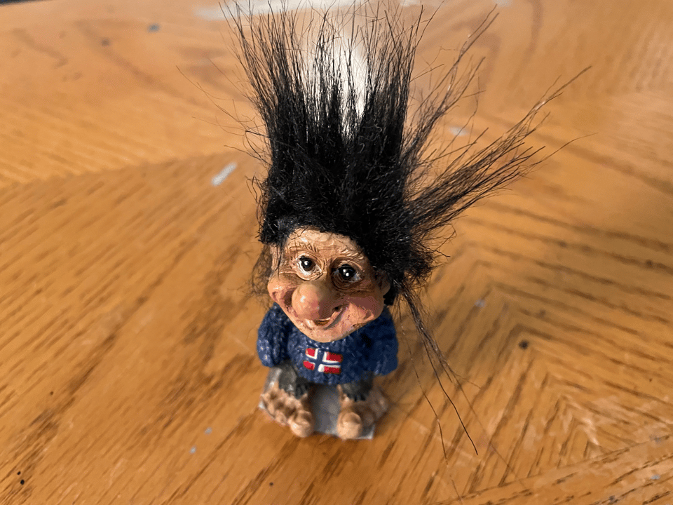 A small souvenir troll doll stares with great intensity