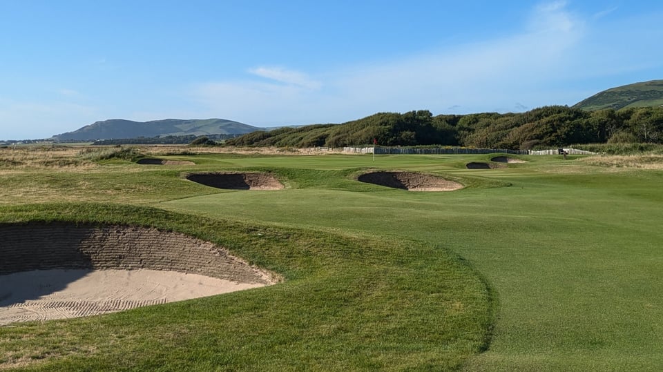 Aberdovey, Gwynedd, Wales in summer, fairway and greenside pot bunkers, blue sky and Snowdonia National Park hills in the background.
