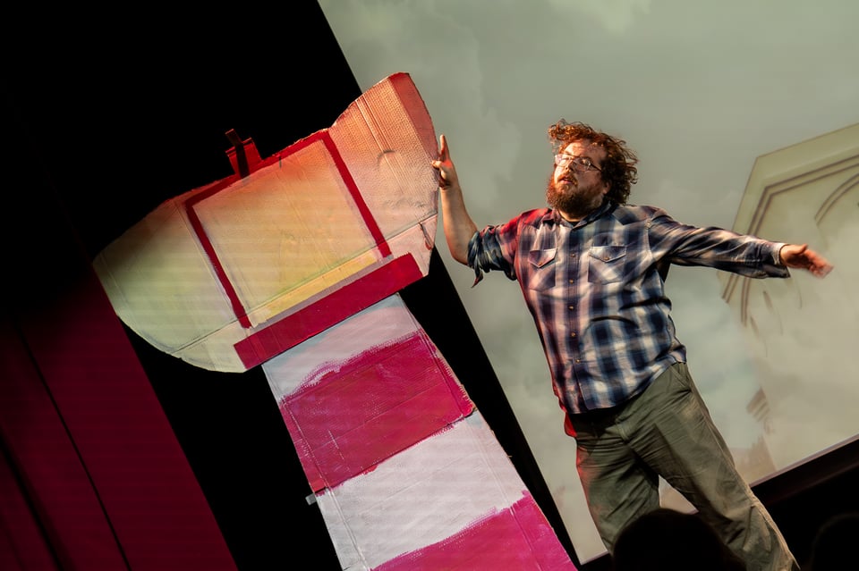 Zach shaking dramatically hile holding the cardboard lighthouse.