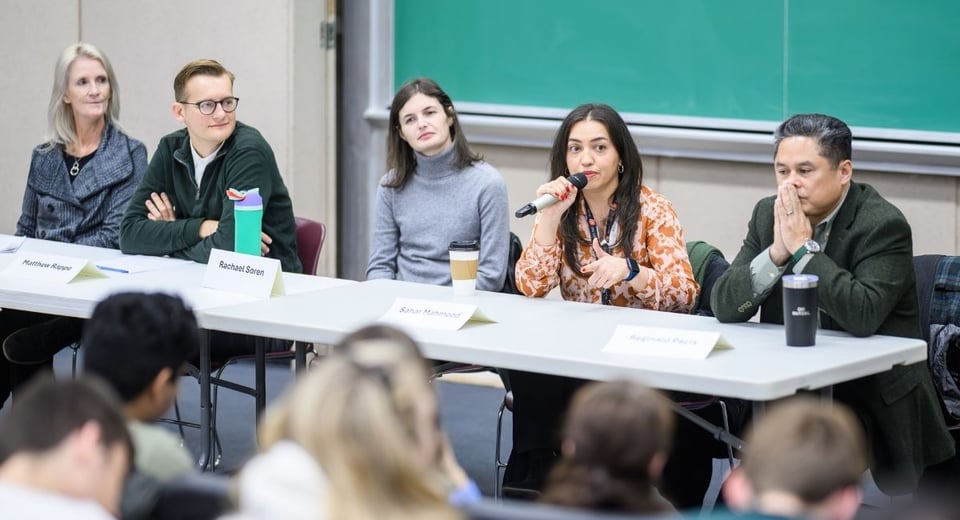 Photo shows five Madison alumni, seated together during an MC 201 lecture.
